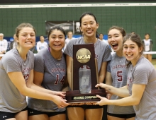 portrait of five volleyball players holding trophy